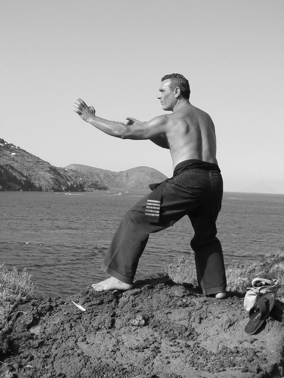 Il Maestro Antonino Torre da giovane, in posizione di guardia su uno scoglio davanti al mare delle Eolie